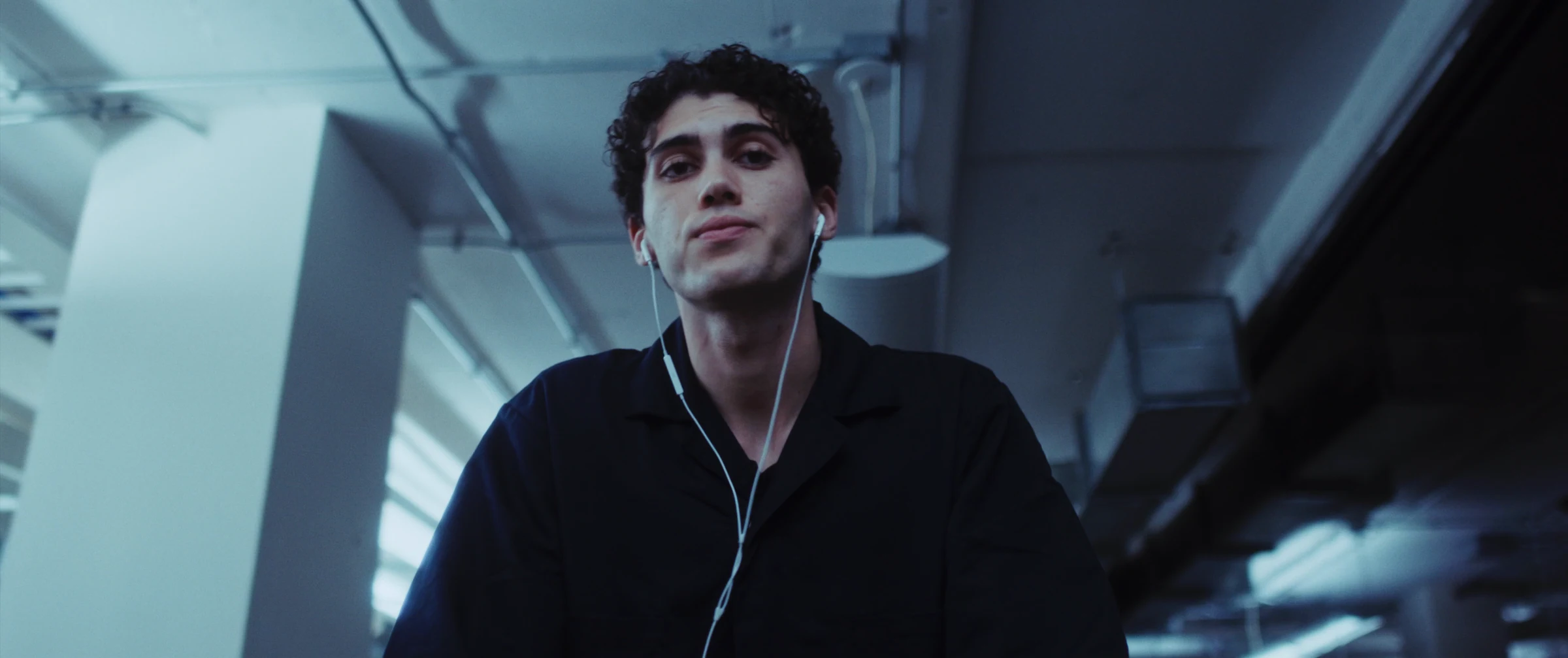 Still from Still Life showing the janitor beneath office lights